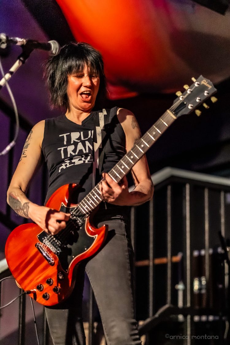 The Sensitives & WHAT With Higheels AgainsT 1 Patsy Stone spielt voll Eifer mit einer roten Gitarre auf einer Bühne