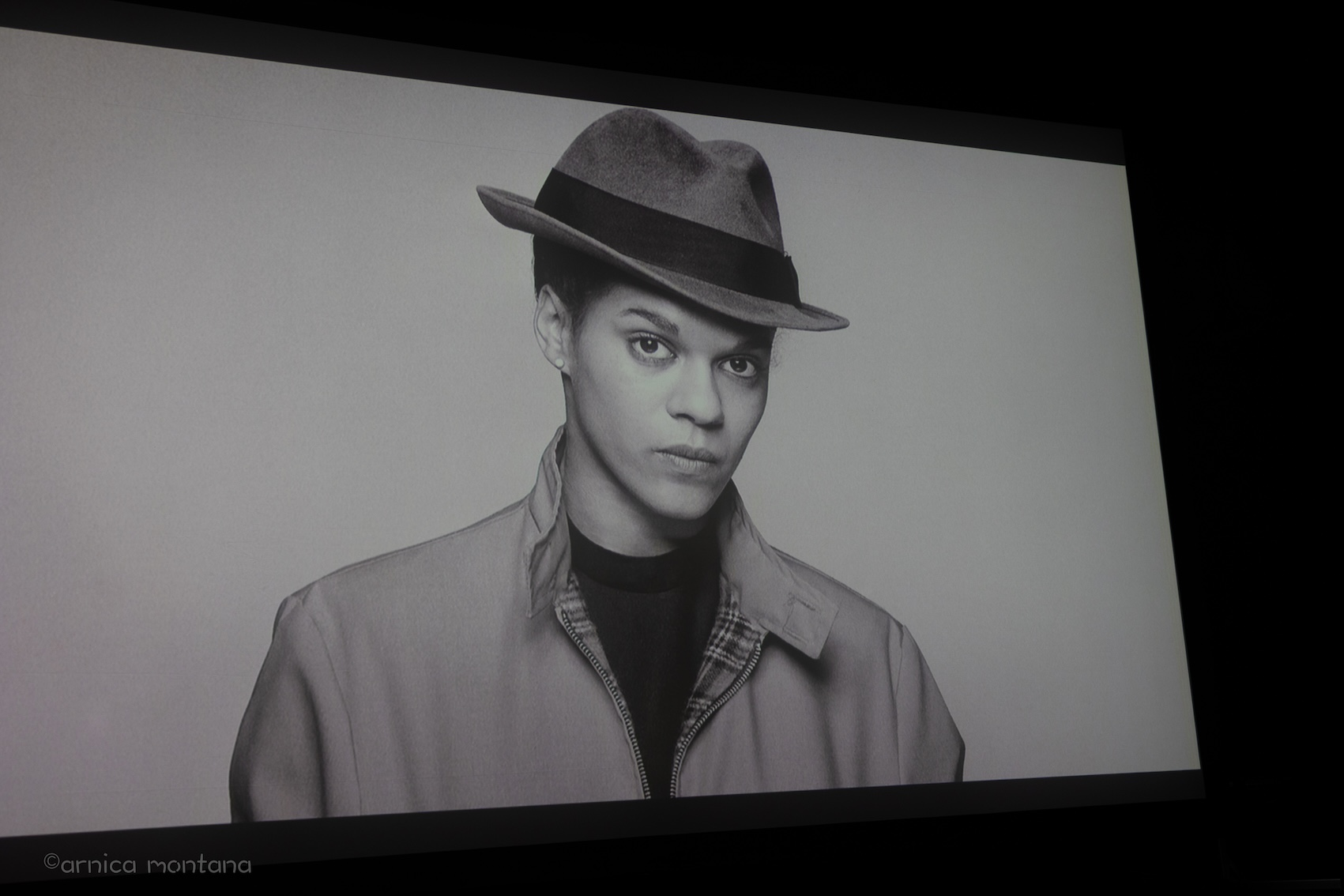 Ein schwarz-weiß Bild mit der jungen Pauline Back mit einem Hut ist auf der Lerinwand zu sehen.