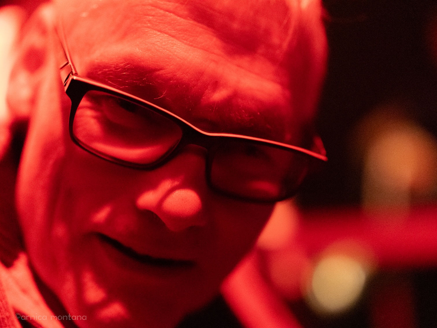 Diversity Dive #15 - The Selecter - Pauline Black: A 2-Tone Story 2 Die Porträtaufnahcme eines gut gelaunten Mannes in rotes Licht getaucht vom SO36.