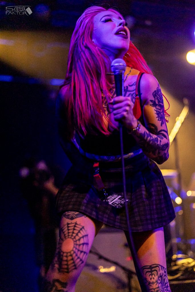 Interview mit Gero / Female Fronted is not a Genre Festival 2026 20 Glückliches Gesicht und Mikrofon in der Hand, eine Sängerin mit tattoos und einem schwarzen Kleid läuft über die Bühne